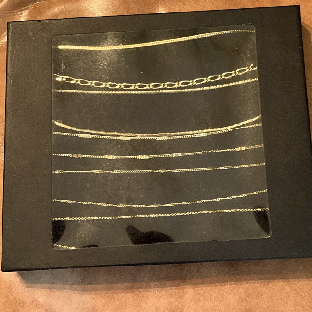 Box of 10 different gold colored bracelets.